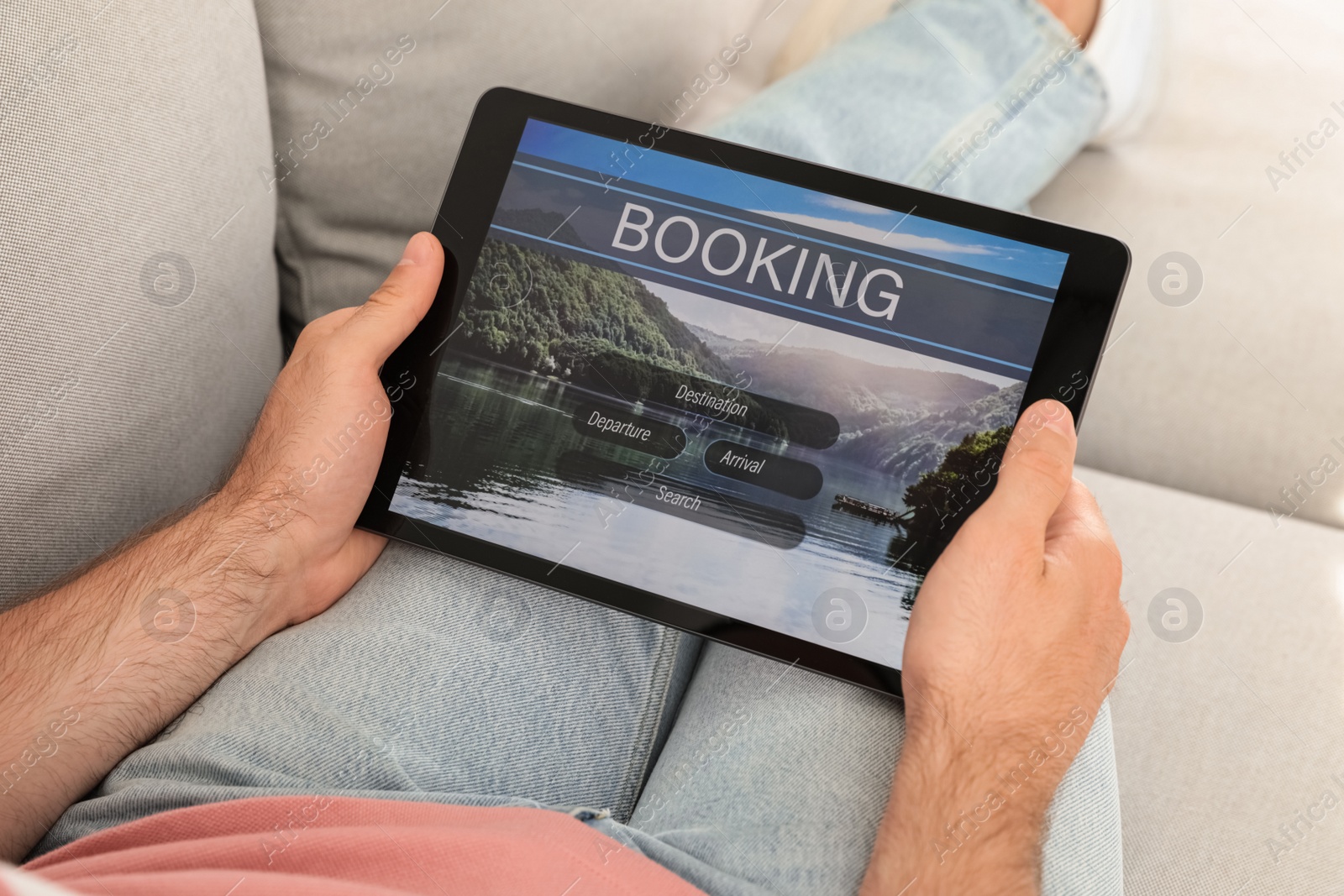 Photo of Man booking tickets online on sofa indoors, closeup. Travel agency concept