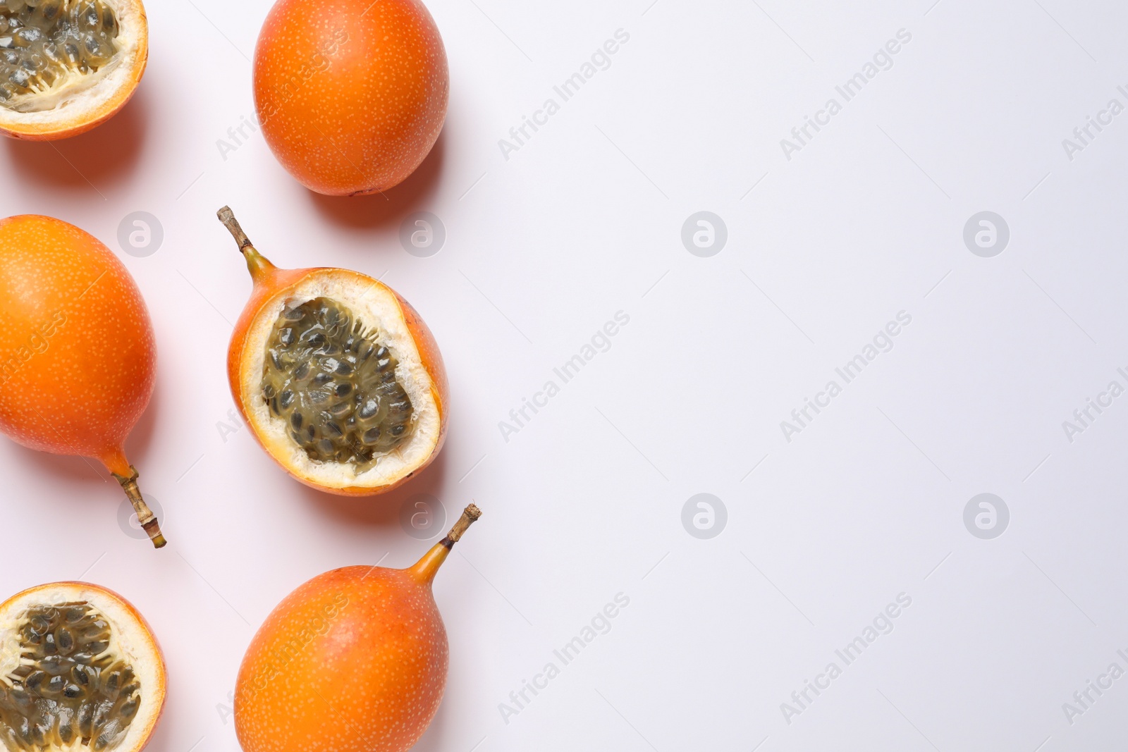 Photo of Delicious ripe granadillas on white background, flat lay