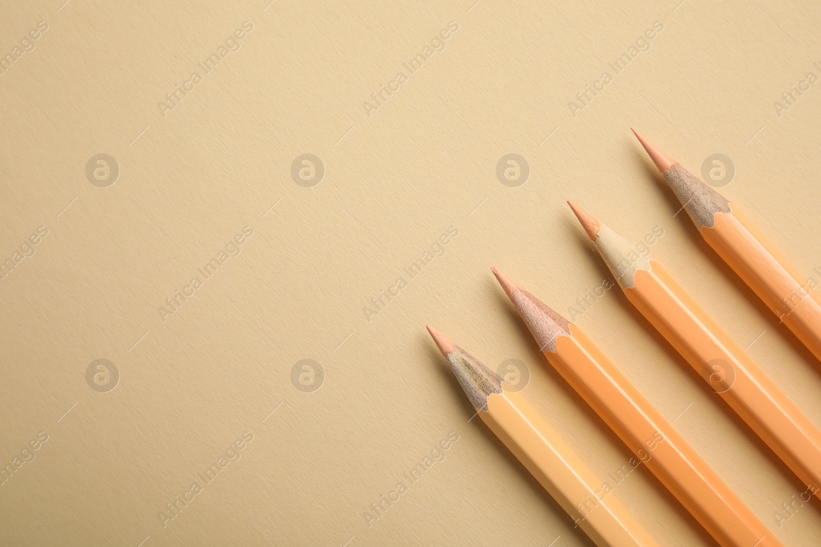 Photo of Flat lay composition with color pencils on beige background. Space for text