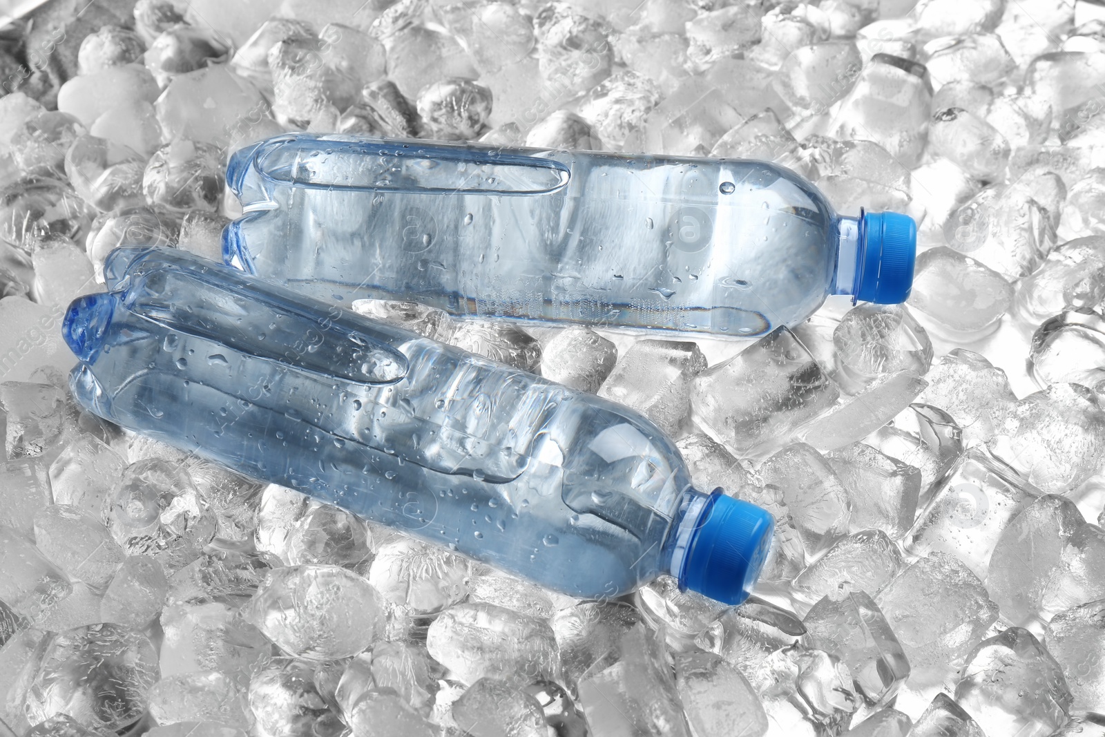 Photo of Bottles of water on pile of ice cubes