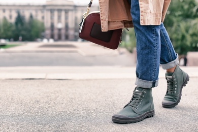 Photo of Young woman in comfortable casual shoes walking on street