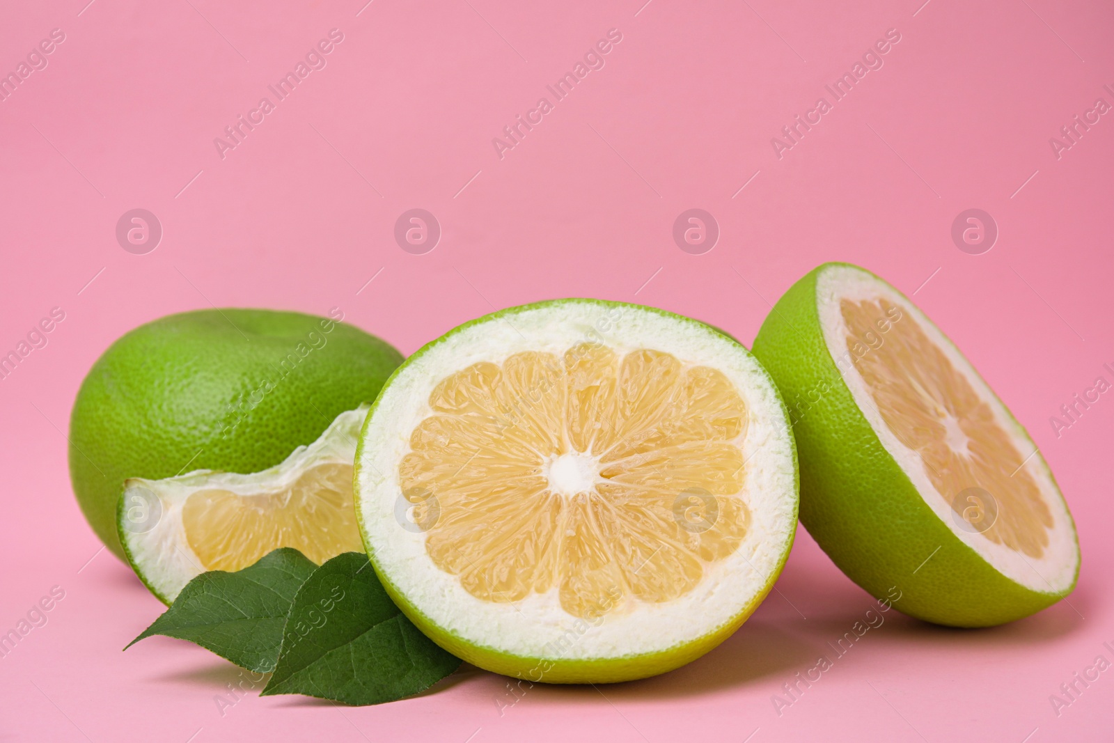 Photo of Tasty whole and cut sweeties on pink background, closeup