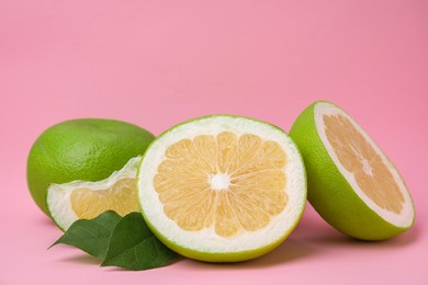 Tasty whole and cut sweeties on pink background, closeup