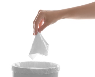 Photo of Woman putting paper tissue into trash bin on white background, closeup