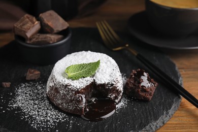 Photo of Delicious fresh fondant with hot chocolate and mint on wooden table