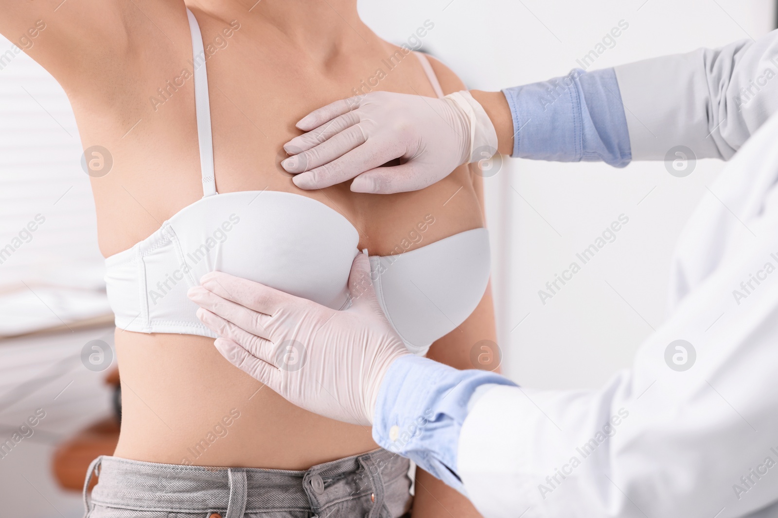 Photo of Mammologist checking woman's breast in hospital, closeup