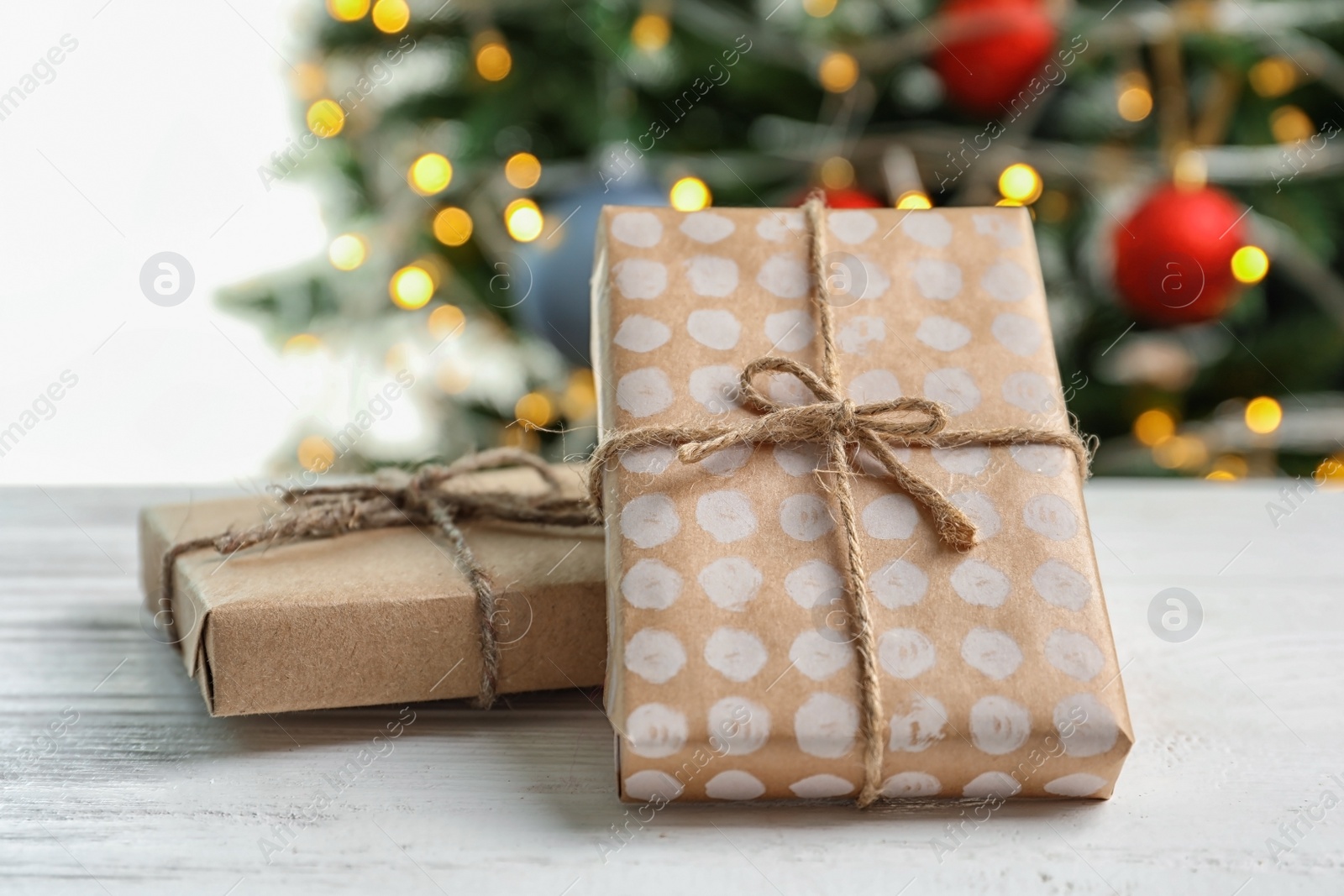 Photo of Beautiful gift boxes and blurred Christmas tree on background