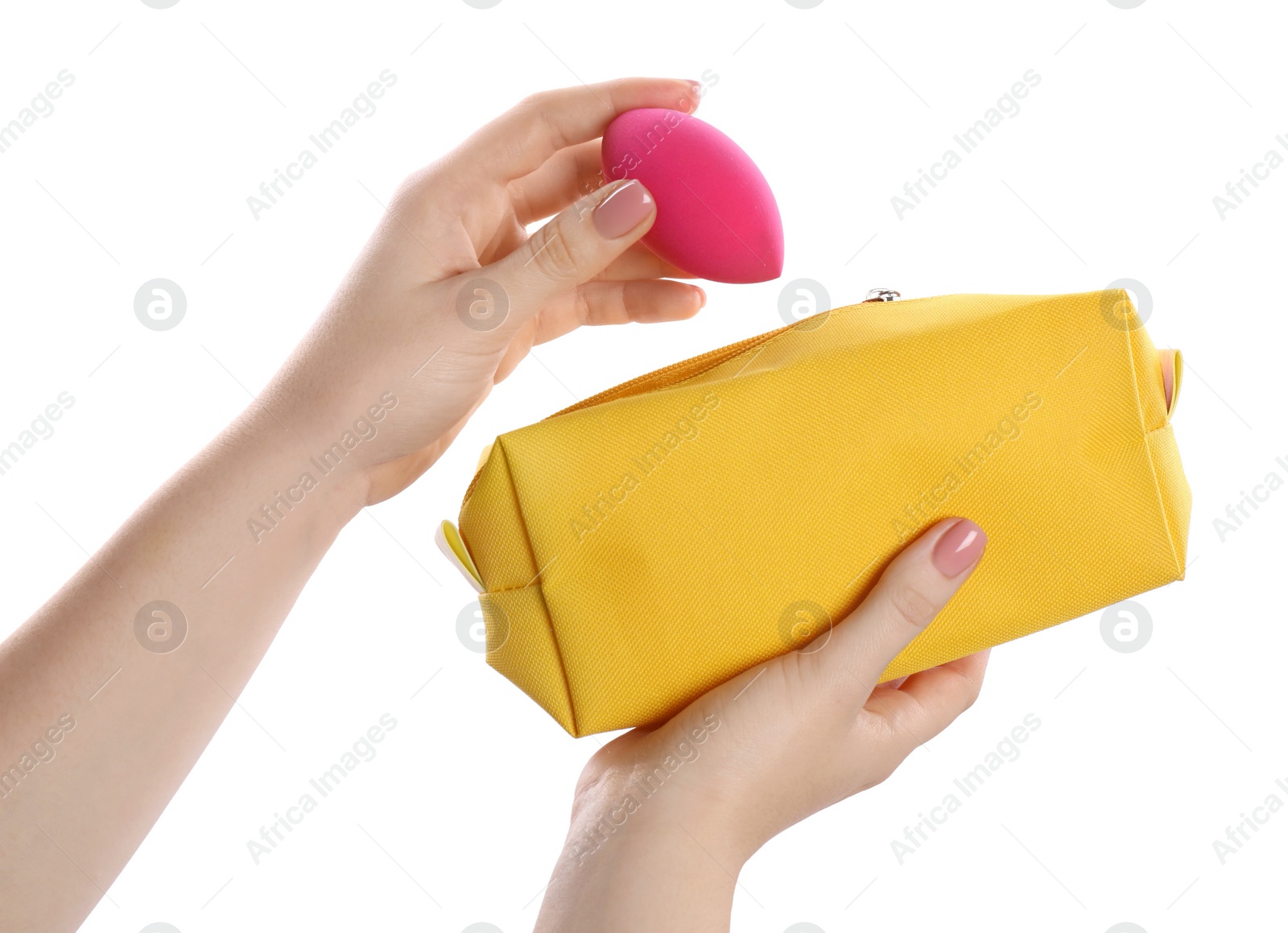 Photo of Woman putting makeup sponge into cosmetic bag on white background, closeup