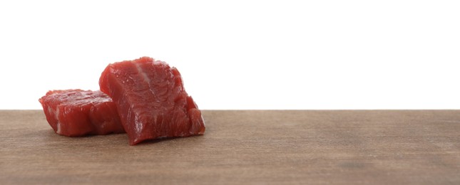 Photo of Pieces of raw cultured meat on wooden table against white background, space for text