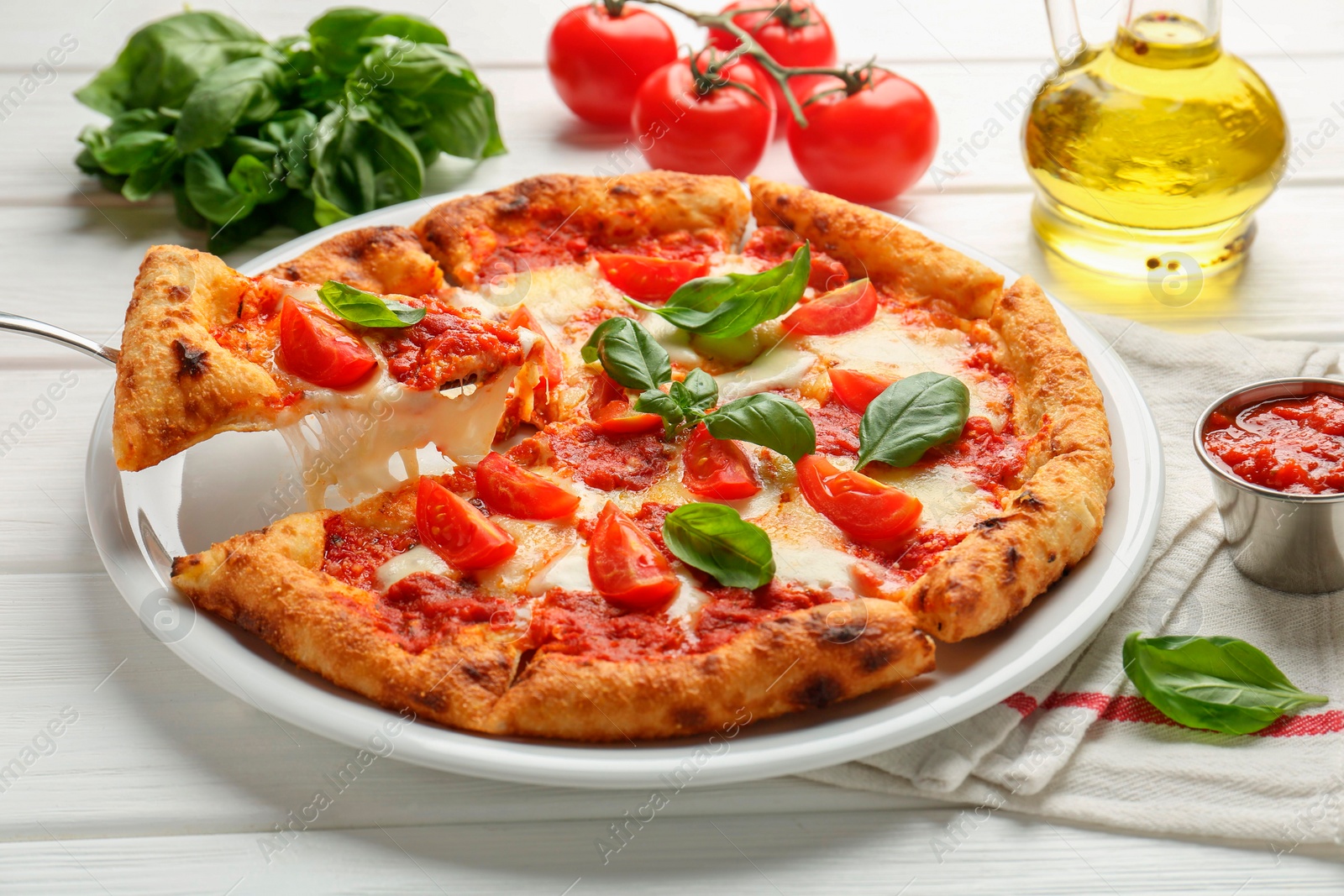 Photo of Taking piece of delicious Margherita pizza at white table, closeup