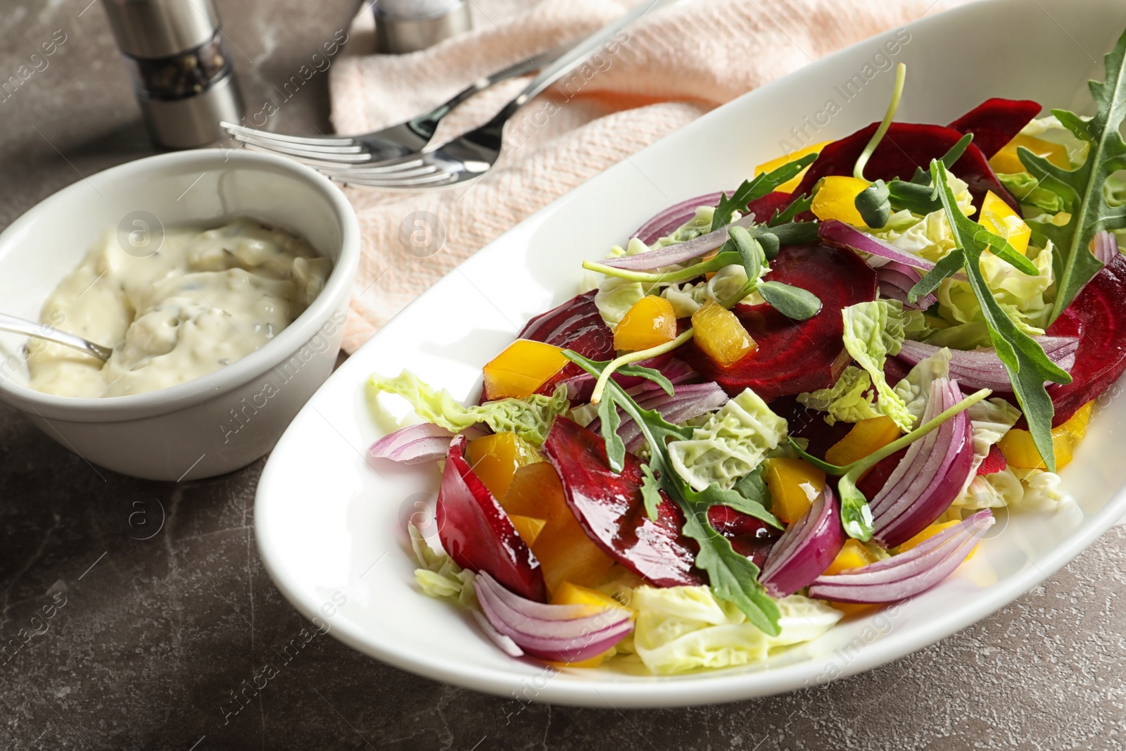 Photo of Bowl with tasty beets salad on gray table