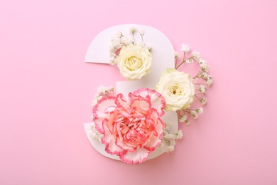 Photo of Paper number 3 and beautiful flowers on pink background, top view