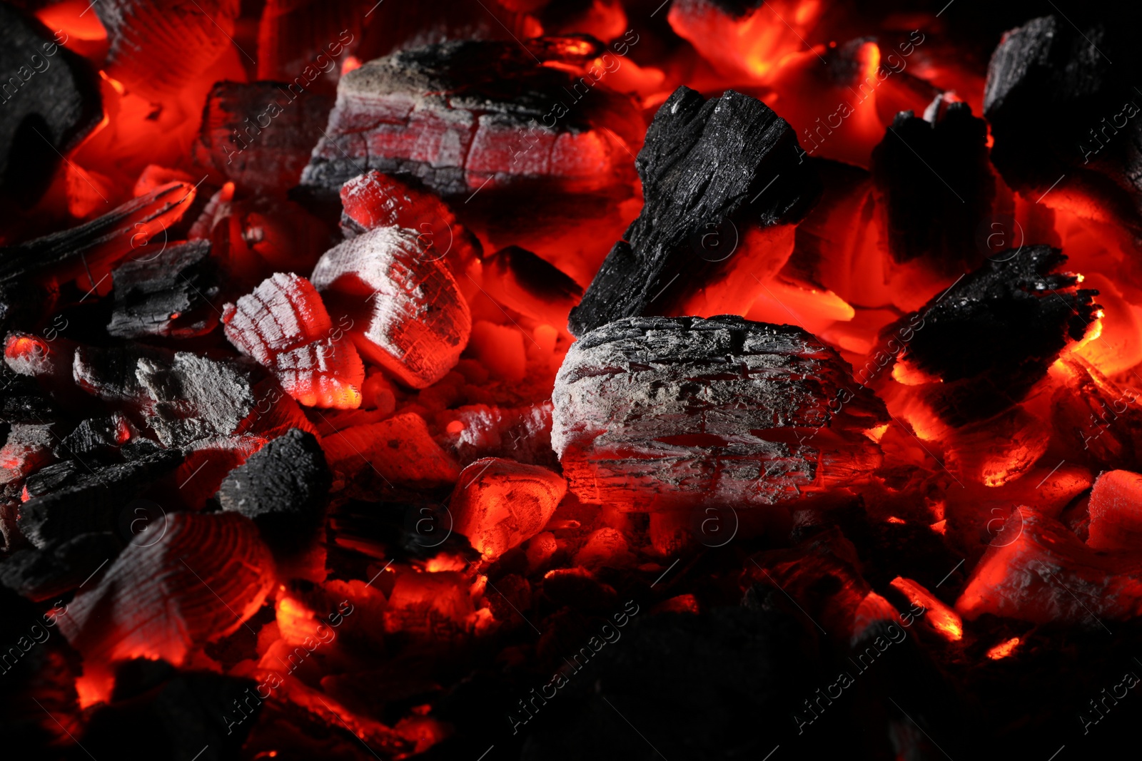 Photo of Pieces of hot smoldering coal as background, closeup