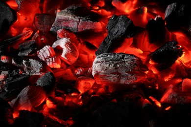 Photo of Pieces of hot smoldering coal as background, closeup