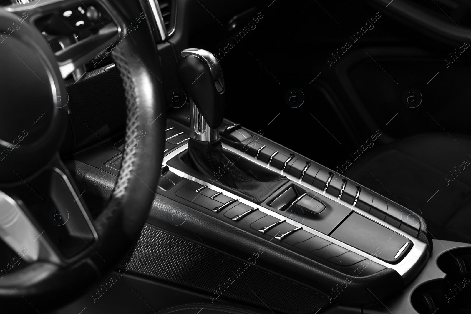 Photo of Gear stick and steering wheel inside of modern black car