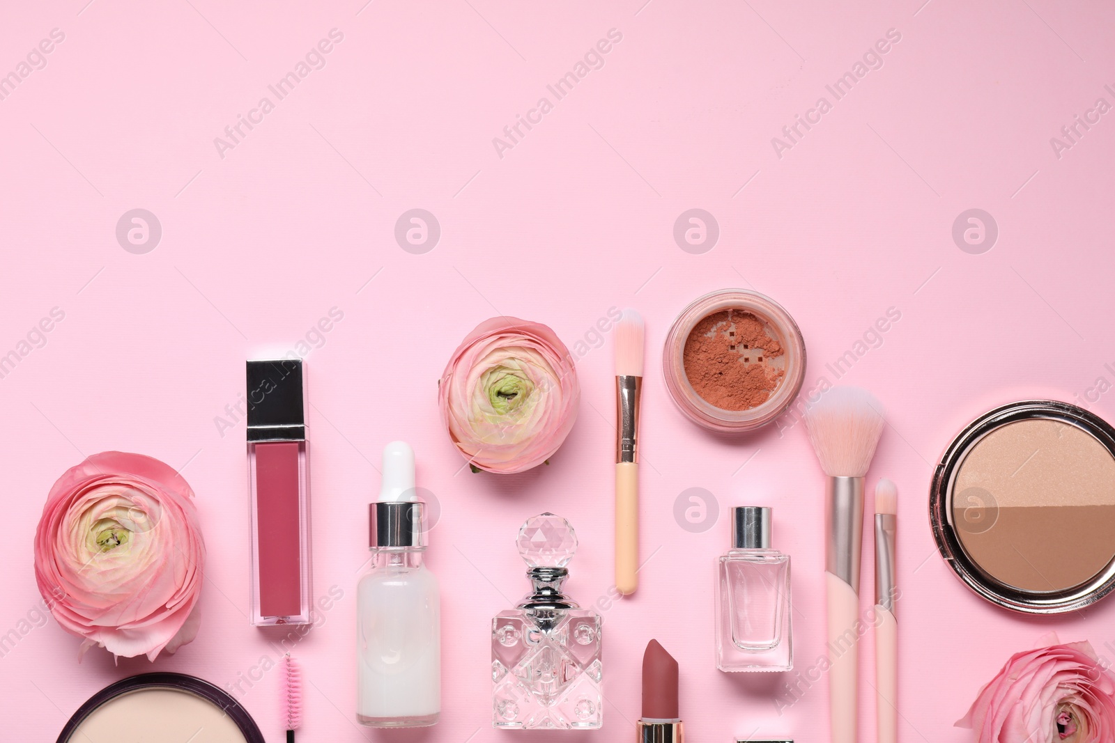 Photo of Flat lay composition with different makeup products and beautiful spring flowers on pink background. Space for text