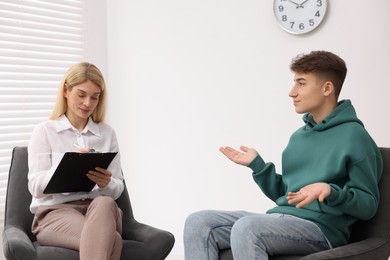 Photo of Psychologist working with teenage boy in office