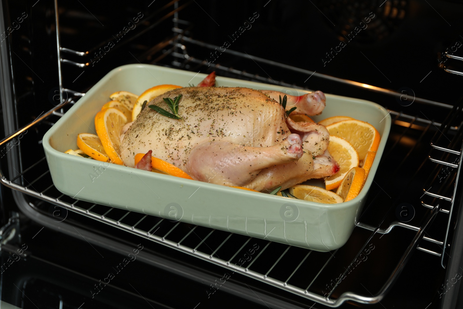 Photo of Chicken with orange slices baking in oven