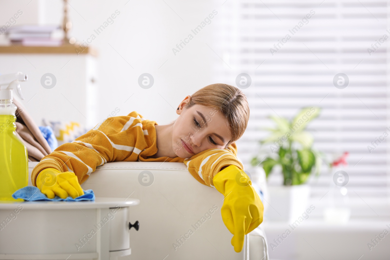 Photo of Lazy young woman wiping table at home. Cleaning and housework