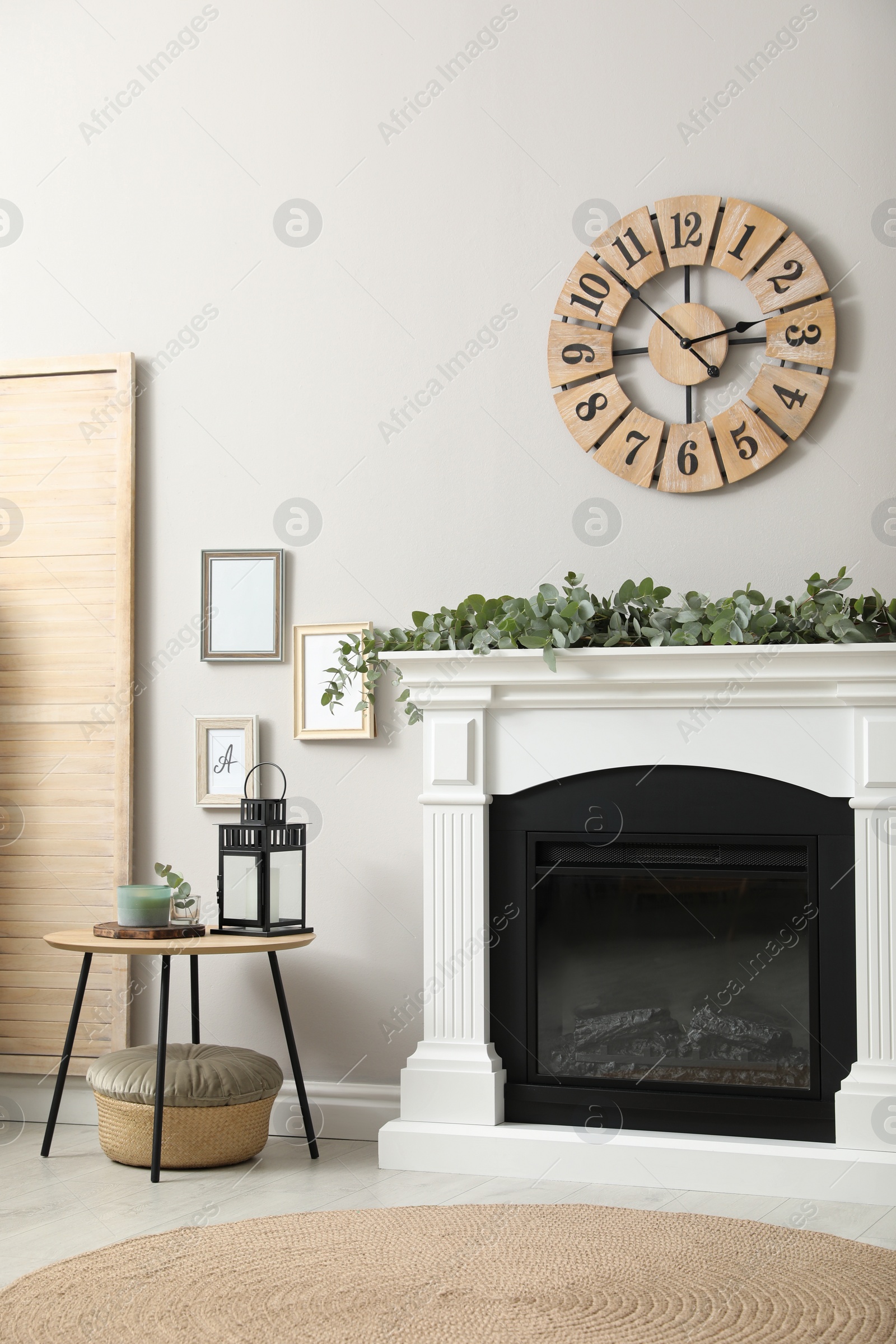 Photo of Stylish room decorated with beautiful eucalyptus garland on fireplace