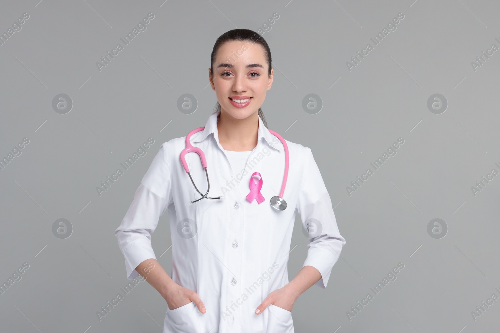 Photo of Mammologist with pink ribbon on gray background. Breast cancer awareness