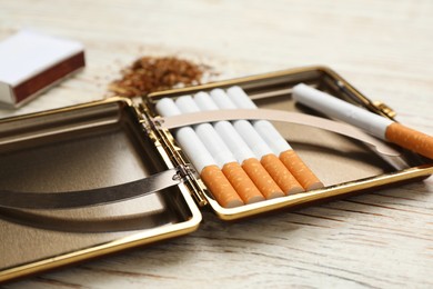 Stylish case with cigarettes on white wooden table, closeup
