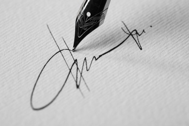 Photo of Signing on sheet of paper with fountain pen, closeup