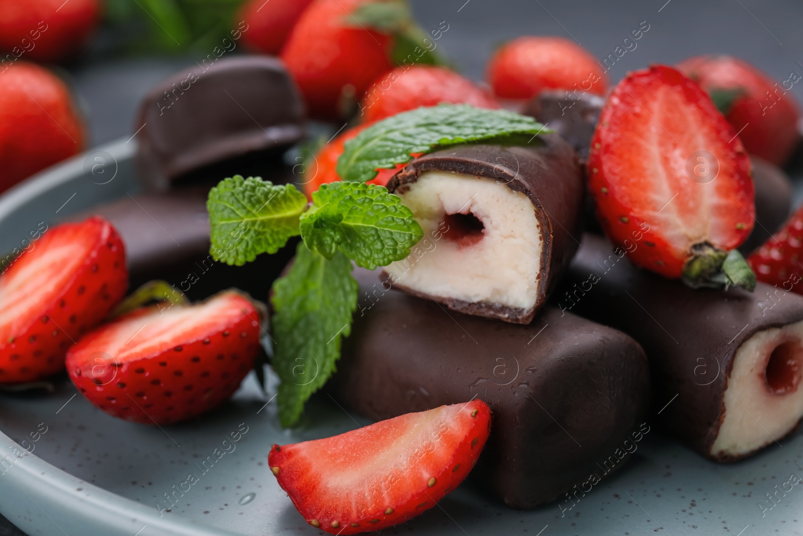 Photo of Delicious glazed curd snacks with fresh strawberries and mint, closeup