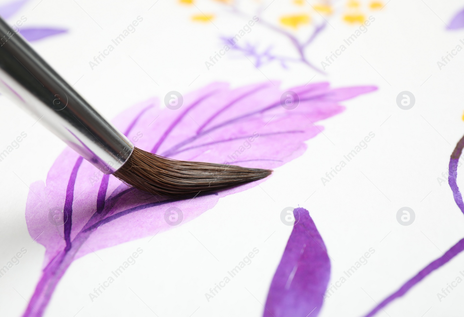 Photo of Painting leaf with watercolor on white paper, closeup