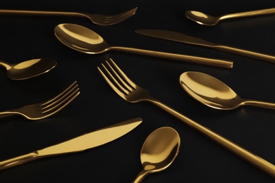 Photo of Set of luxury gold cutlery on black background