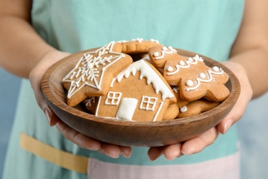 Photo of Woman holding plate with tasty homemade Christmas cookies, closeup