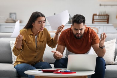 Photo of Young couple having argument about family budget at home