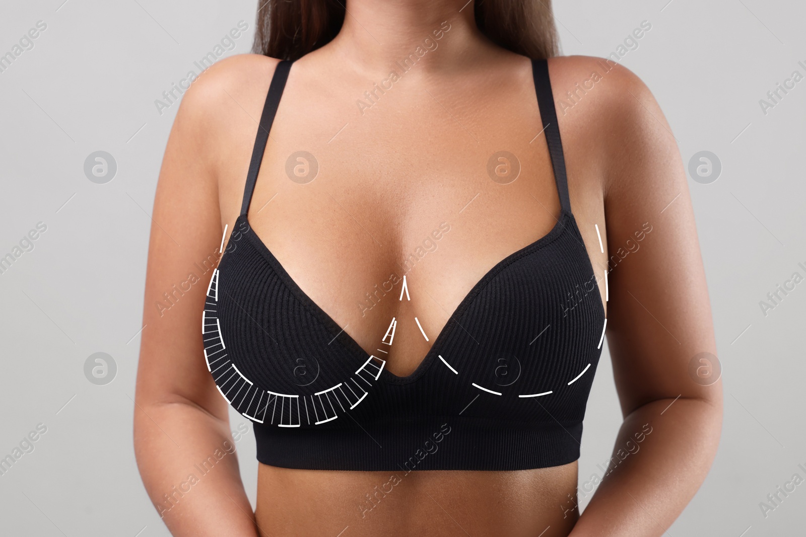 Image of Woman with breast asymmetry on light grey background, closeup