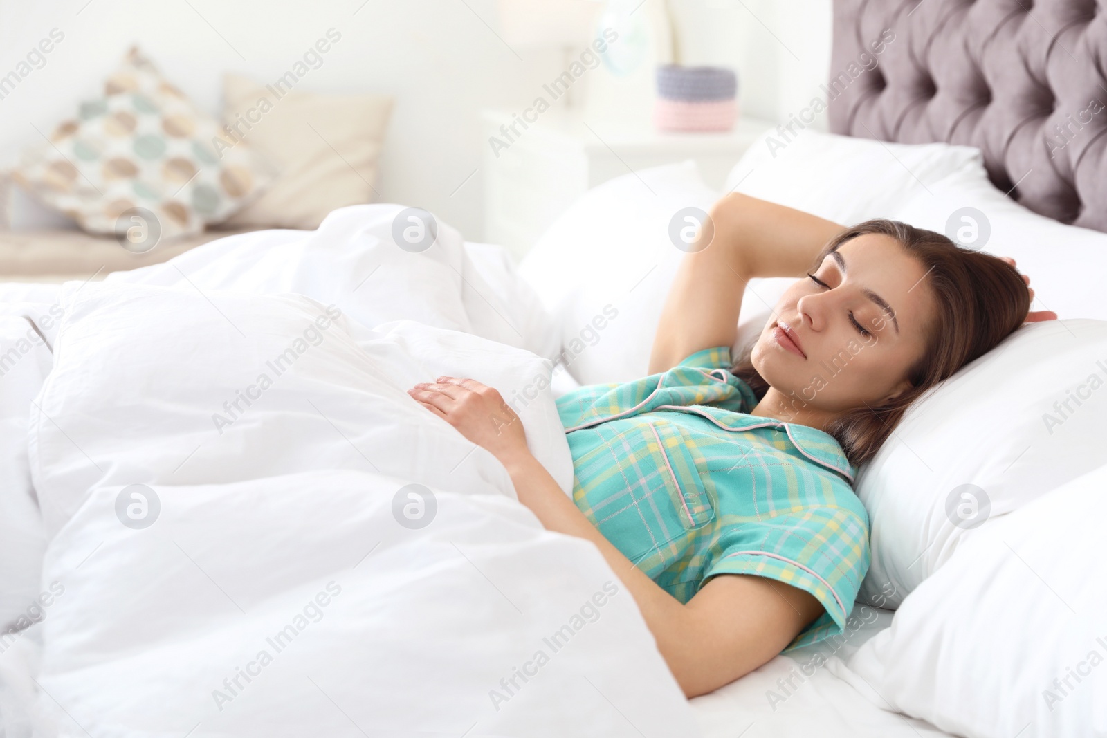 Photo of Portrait of beautiful young woman sleeping in large bed