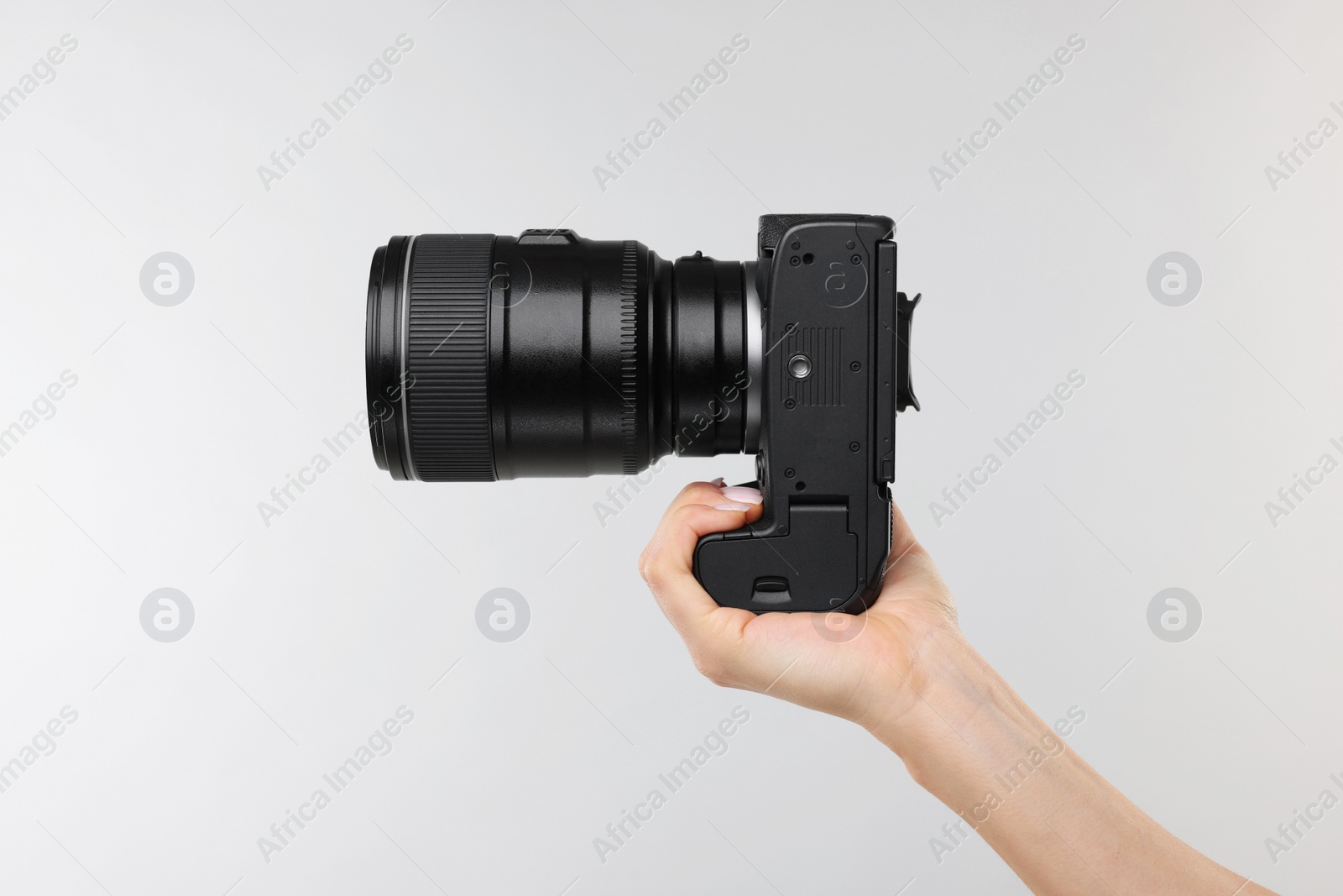 Photo of Photographer with camera on light grey background, closeup