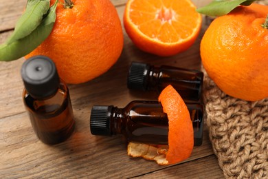 Photo of Composition with tangerine essential oil on wooden table