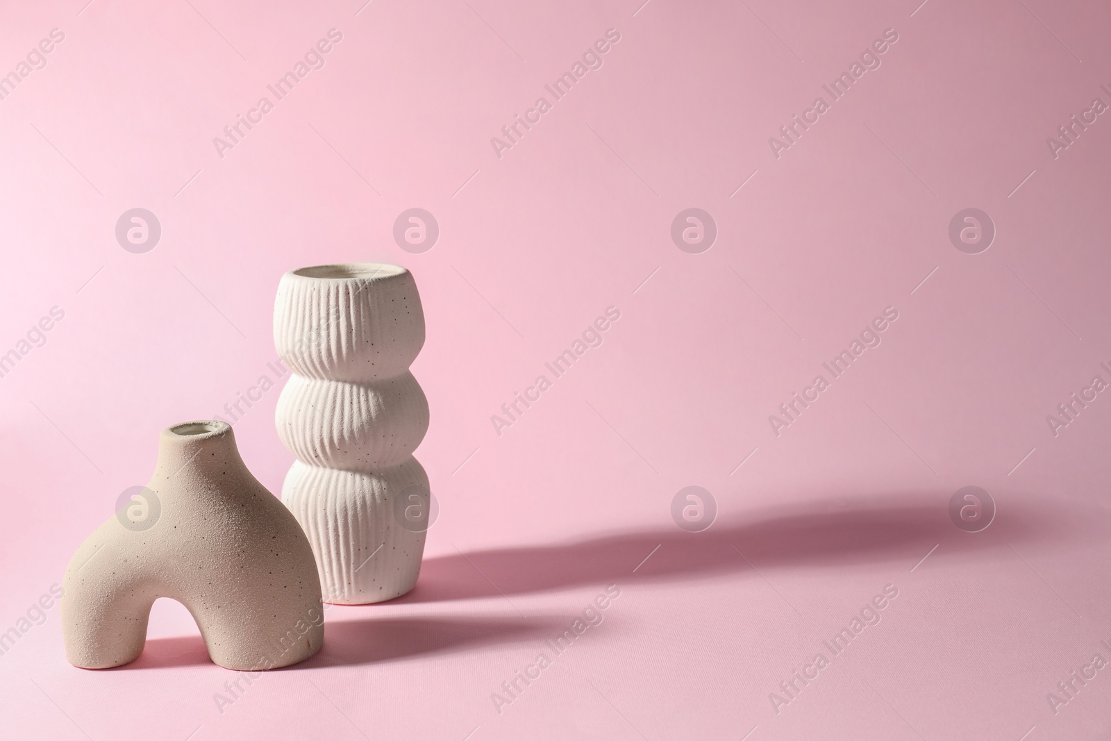 Photo of Two stylish vases on pink background, space for text