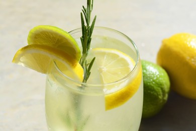 Photo of Summer refreshing lemonade and ingredients on light grey table, closeup
