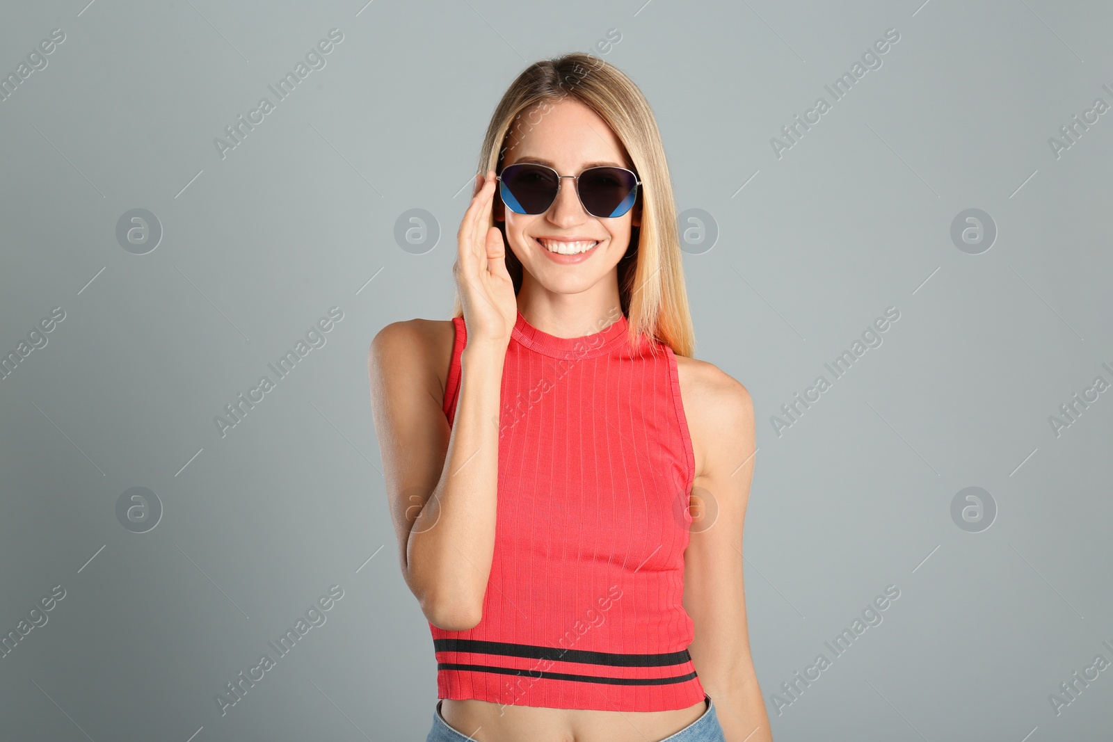 Photo of Beautiful woman in stylish sunglasses on grey background