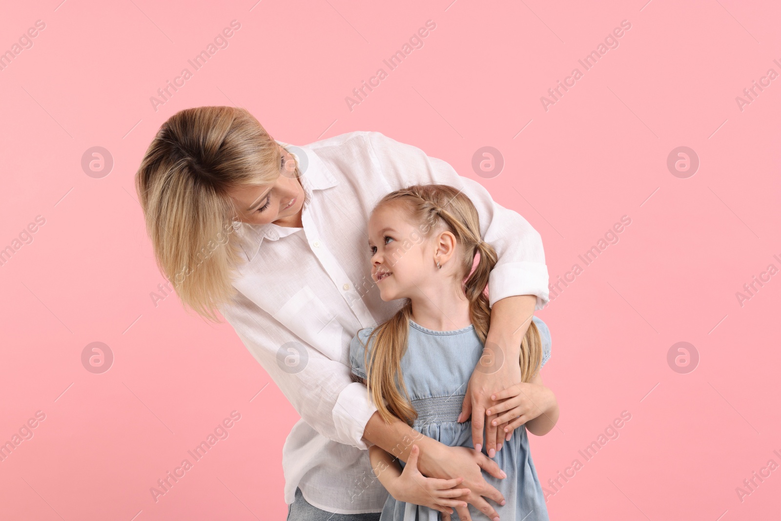 Photo of Family portrait of happy mother and daughter on pink background
