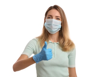Photo of Young woman in medical gloves and protective mask showing thumb up on white background
