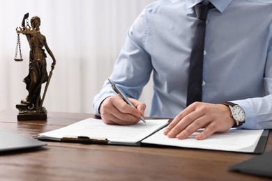 Photo of Lawyer working with documents at wooden table in office, closeup