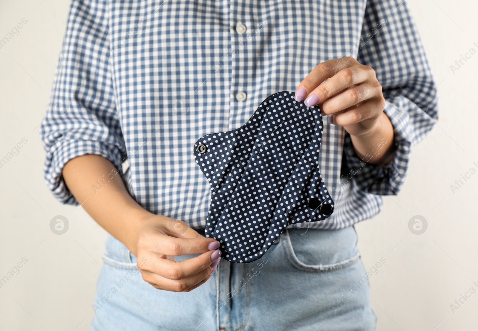 Photo of Woman holding reusable cloth menstrual pad isolated on white, closeup