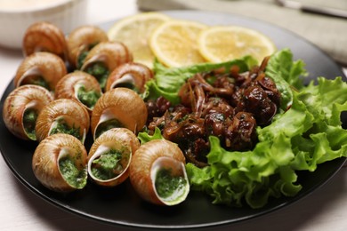 Photo of Delicious cooked snails served on white table, closeup
