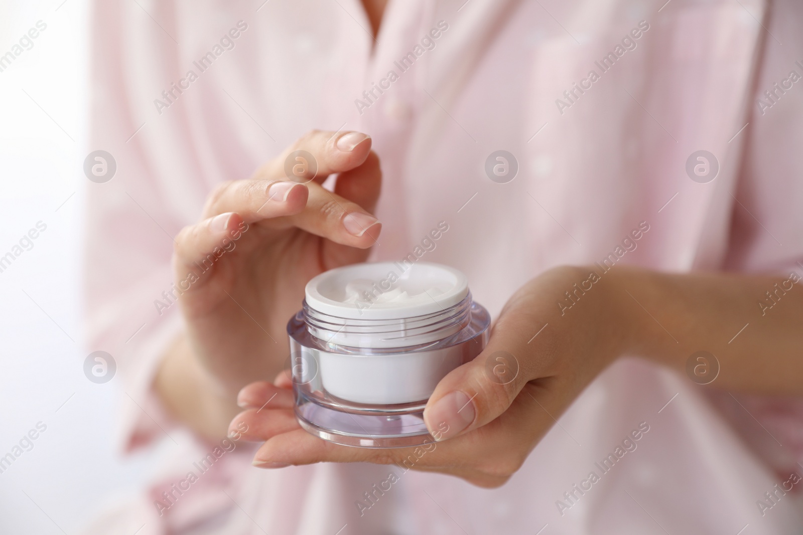 Photo of Woman with jar of moisturizing cream, closeup