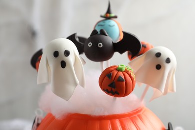 Photo of Different Halloween themed cake pops on light background, closeup