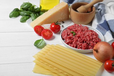Photo of Fresh ingredients for lasagna on white wooden table
