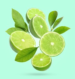 Image of Fresh lime fruits and green leaves falling on aquamarine background