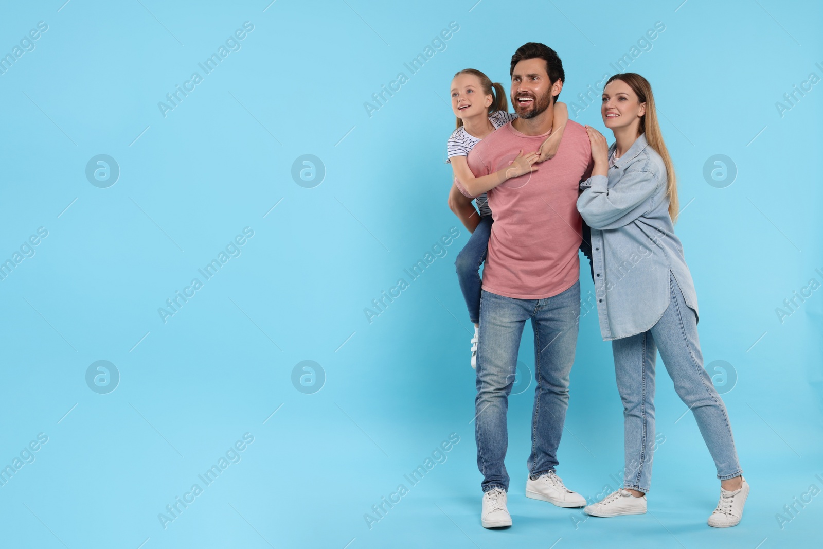 Photo of Happy family on light blue background, space for text