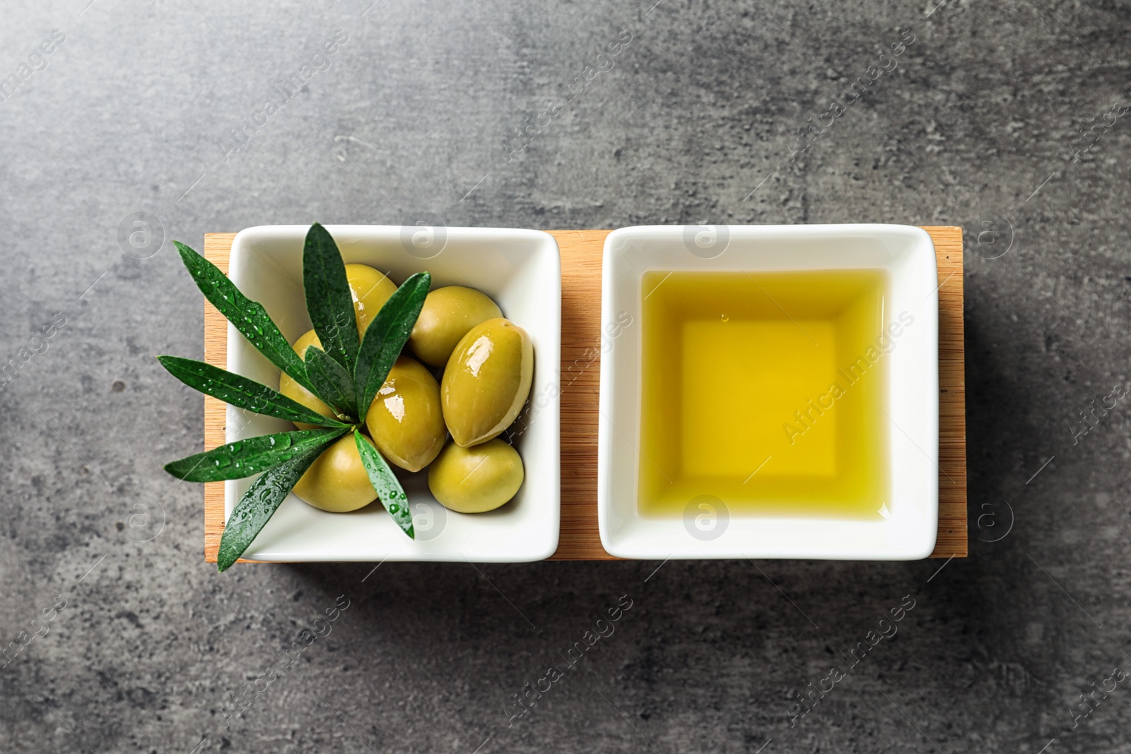 Photo of Dishes with olive oil and ripe olives on table, top view